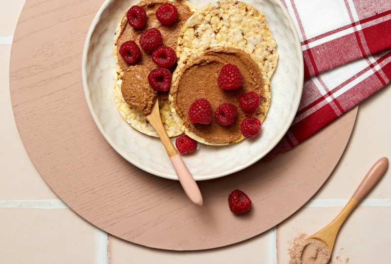 Almond Butter mixed with Choc Protein Powder & Raspberries on Corn Thins slices